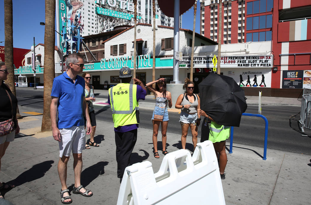 Security guards stop pedestrians to let them know that Fremont Street is closed for pedestrian ...