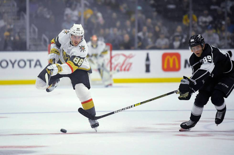 Vegas Golden Knights defenseman Nate Schmidt, left, passes the puck as Los Angeles Kings center ...