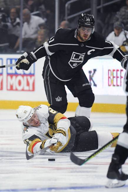 Vegas Golden Knights center Jonathan Marchessault, below, falls as he passes the puck while und ...