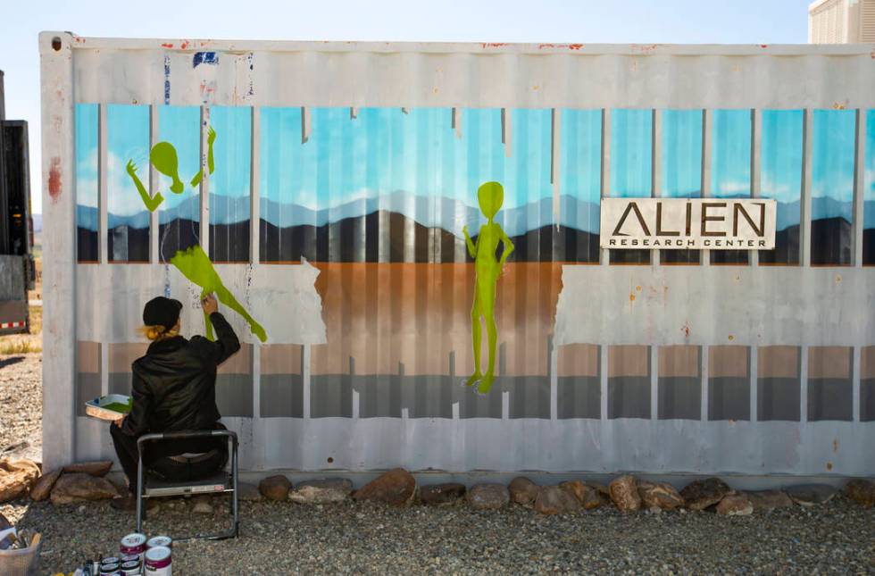 Artist Brandy Whisenant continues to paint a mural on the side of a container about the Area 51 ...