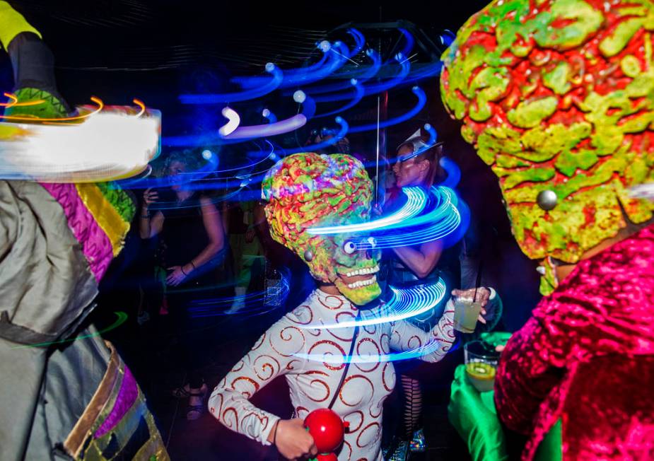 Attendees dressed as characters from the movie "Mars Attacks!" dance during a pre-party for Sto ...