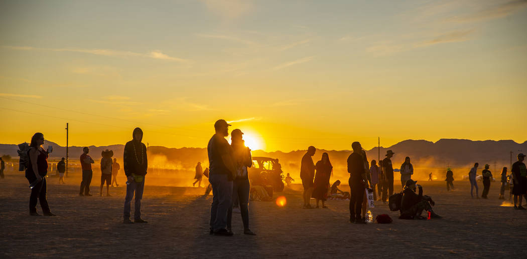 The sun sets on the second day as festivalgoers enjoy music from the main stage during the Alie ...