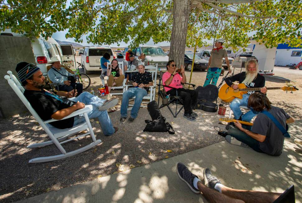 Festivalgoers relax and enjoy some music under the tree at the Little A'Le'Inn during the Alien ...