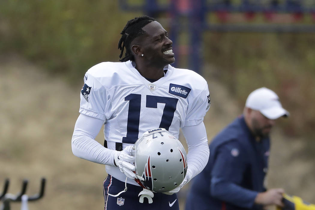 New England Patriots wide receiver Antonio Brown carries his helmet during an NFL football prac ...