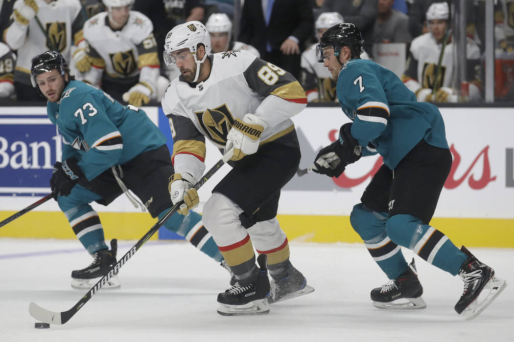 Vegas Golden Knights right wing Alex Tuch (89) skates between San Jose Sharks centers Noah Greg ...