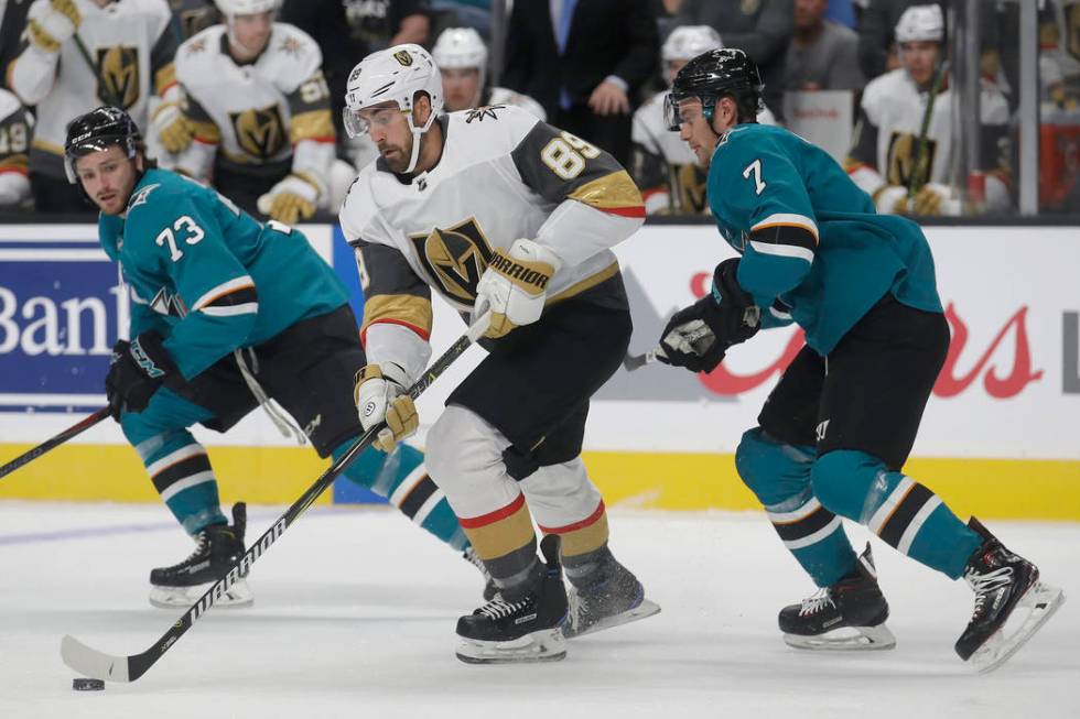 Vegas Golden Knights right wing Alex Tuch (89) skates between San Jose Sharks centers Noah Greg ...