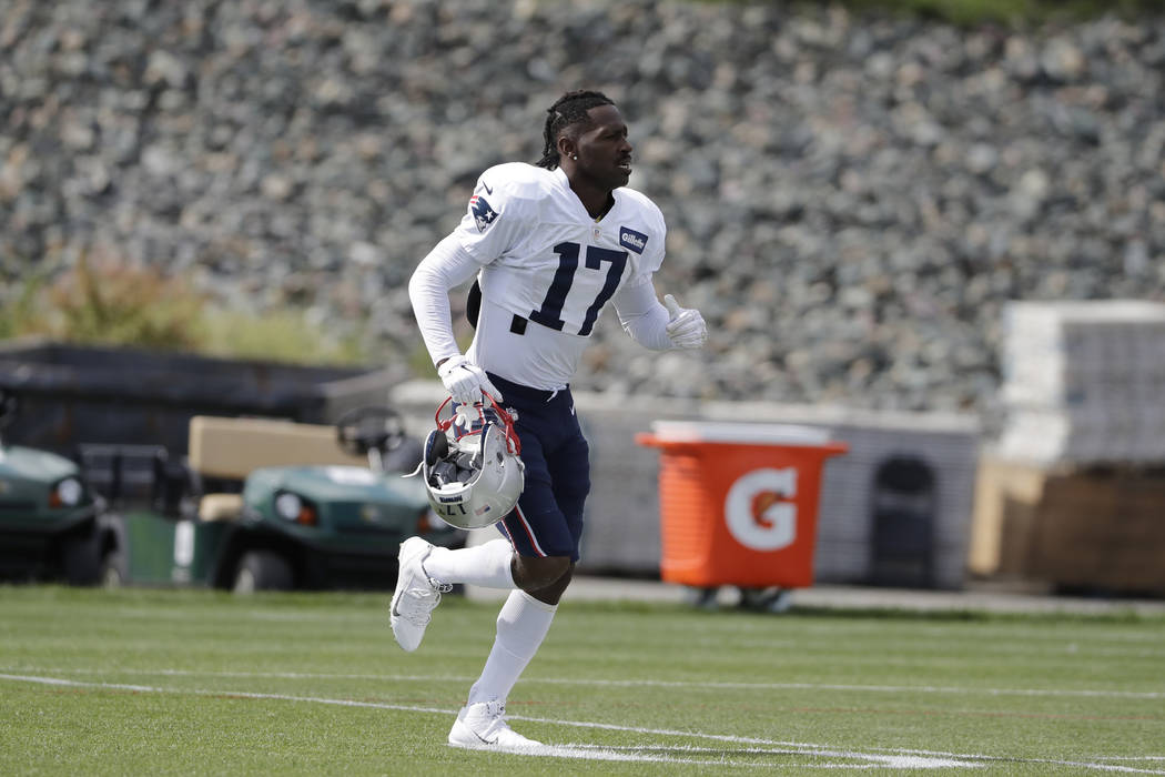 New England Patriots wide receiver Antonio Brown carries his helmet during an NFL football prac ...
