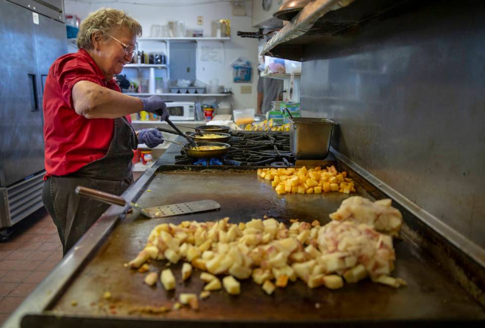 Pat Travis of the Little A'Le'Inn cooks breakfast for customers as usual with the help of famil ...