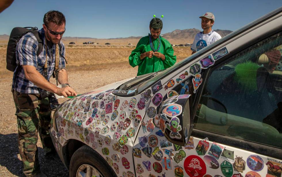 Festivalgoers add stickers to a car parked on the frontage road during the Alienstock festival ...