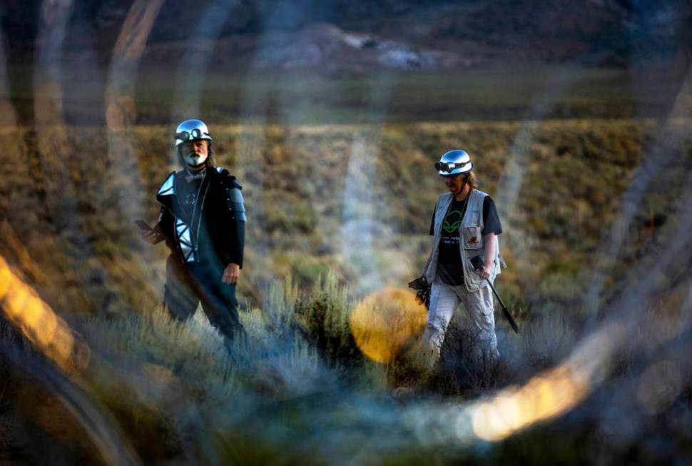 Matthew Devlen and Kim Dillinger Davis walk along the fence line with razor wire at the back ga ...