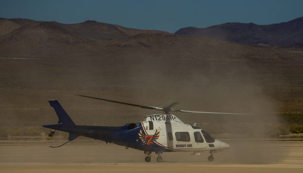 A Mercy Air helicopter prepares to lift off with two injured in a vehicle rollover on the salt ...