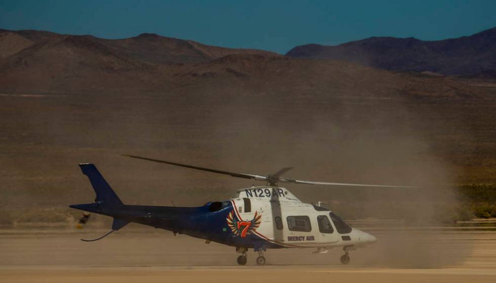 A Mercy Air helicopter prepares to lift off with two injured in a vehicle rollover on the salt ...