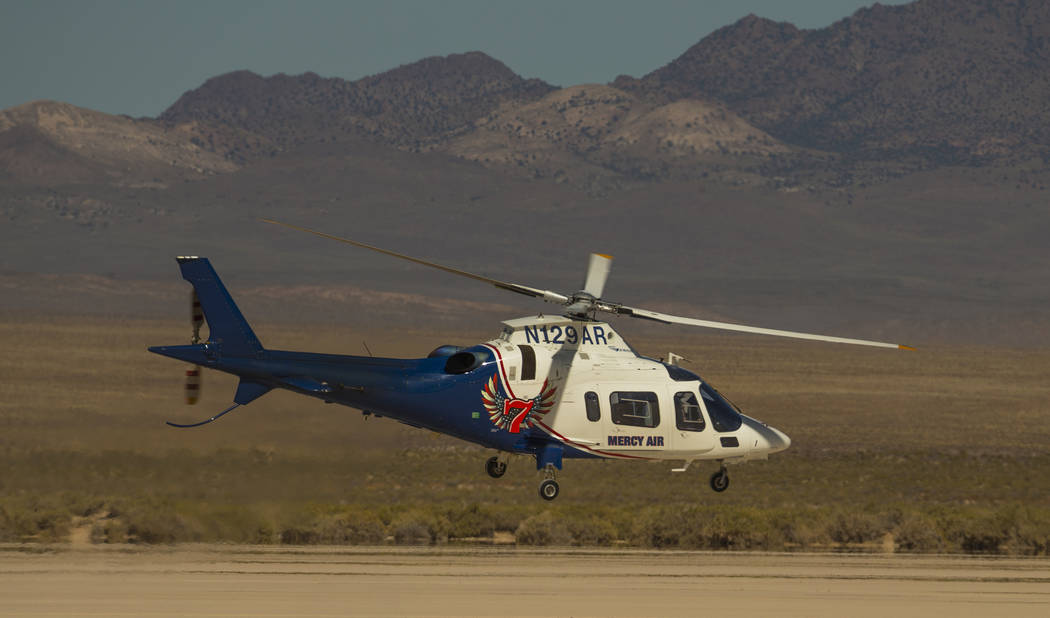 A Mercy Air helicopter lifts off with two injured in a vehicle rollover on the salt flats just ...