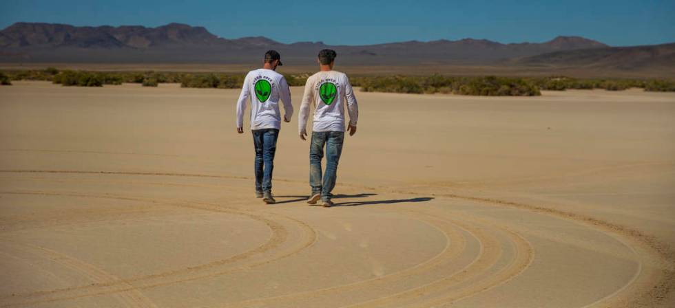 Festivalgoers connected to the scene of a vehicle rollover take a walk to clear their heads as ...