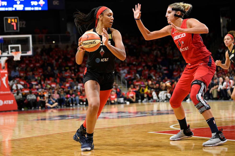 Las Vegas Aces center A'ja Wilson, left, dribbles the ball against Washington Mystics forward E ...