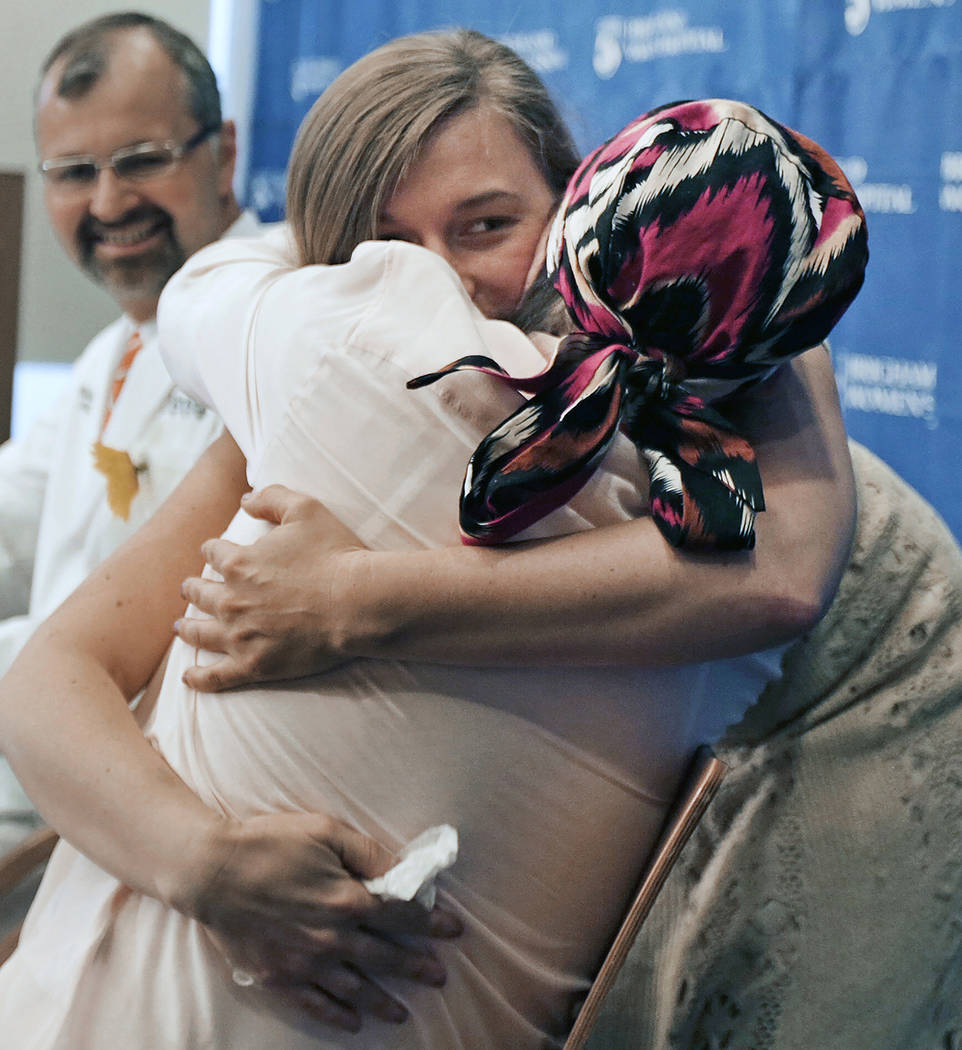 Marinda Righter, daughter of face donor Cheryl Denelli-Righter, embraces recipient Carmen Bland ...