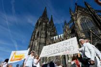 Protesters build a human chain in front of the Cologne Cathedral in Cologne, Germany, Sunday, S ...