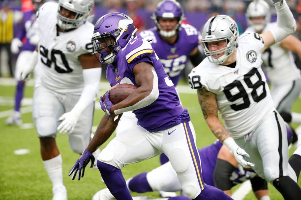 Minnesota Vikings running back Dalvin Cook (33) runs from Oakland Raiders defensive end Maxx Cr ...