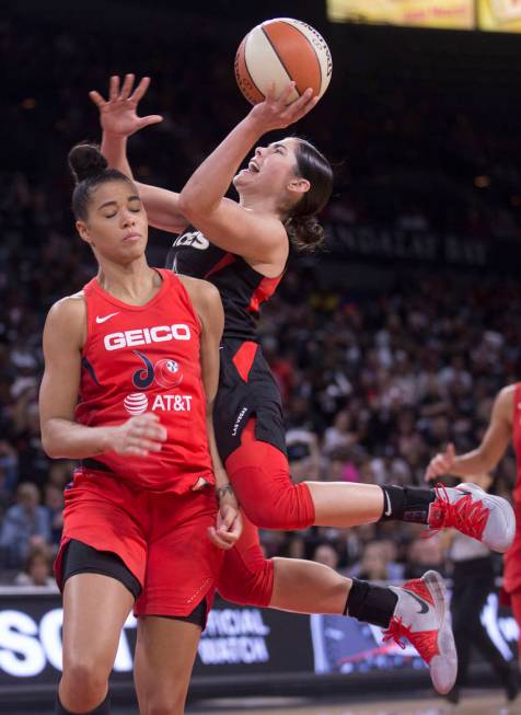 Las Vegas Aces guard Kelsey Plum (10) drives over Washington Mystics guard Natasha Cloud (9) in ...