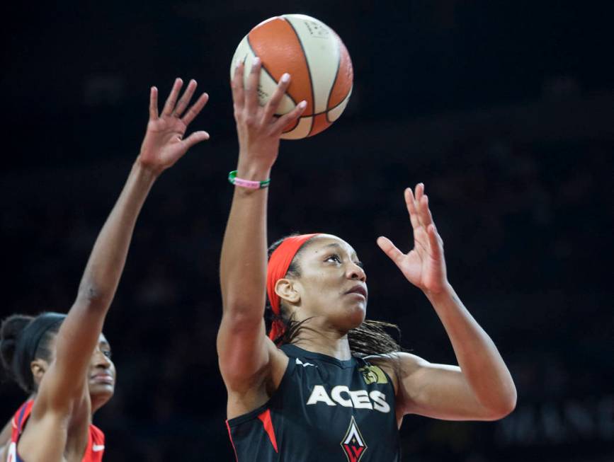 Las Vegas Aces center A'ja Wilson (22) drives past a Washington Mystics defender in the first q ...