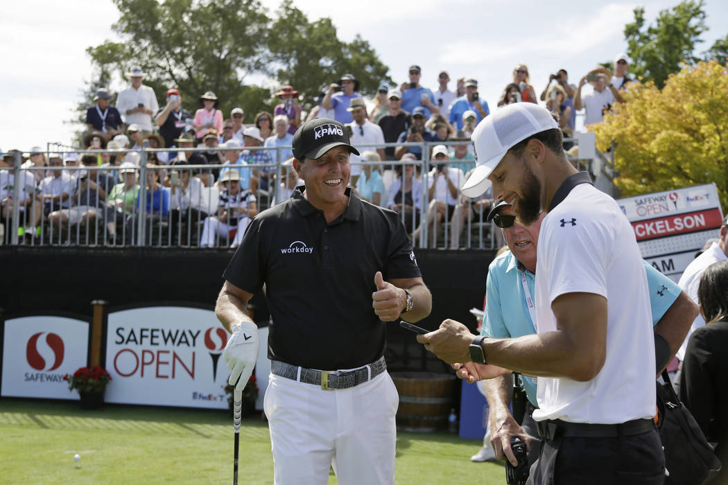 Phil Mickelson, left, talks with Stephen Curry on the first tee of the Silverado Resort North C ...