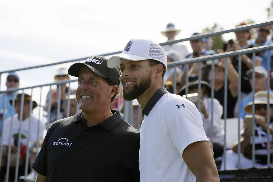 Phil Mickelson, left, and Stephen Curry pose for pictures before hitting from the first tee of ...