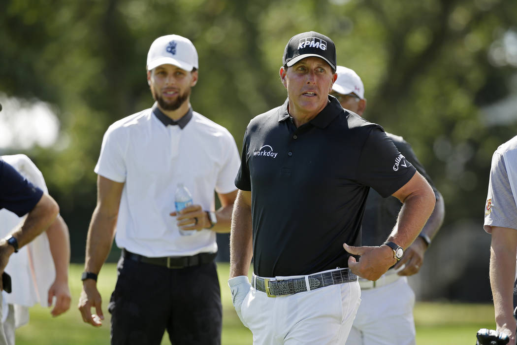 Phil Mickelson, right, and Stephen Curry on the first fairway of the Silverado Resort North Cou ...