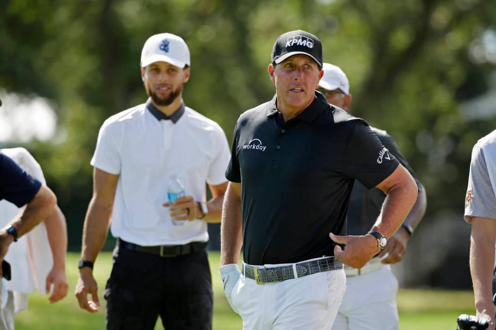 Phil Mickelson, right, and Stephen Curry on the first fairway of the Silverado Resort North Cou ...