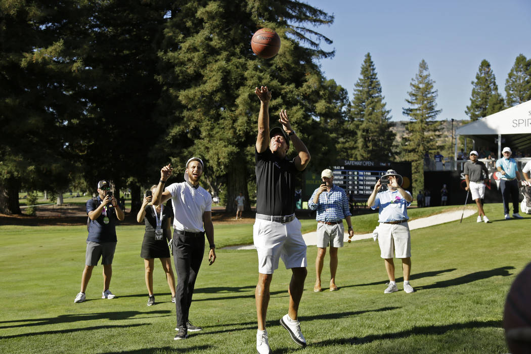 Phil Mickelson shoots a basketball below the 17th green of the Silverado Resort North Course as ...