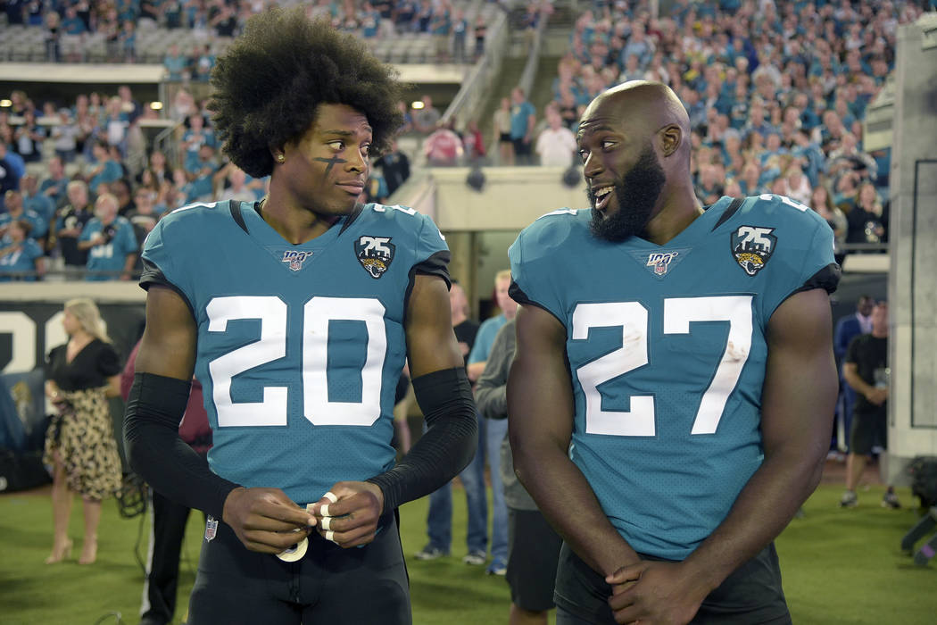 Jacksonville Jaguars cornerback Jalen Ramsey (20) talks to running back Leonard Fournette (27) ...