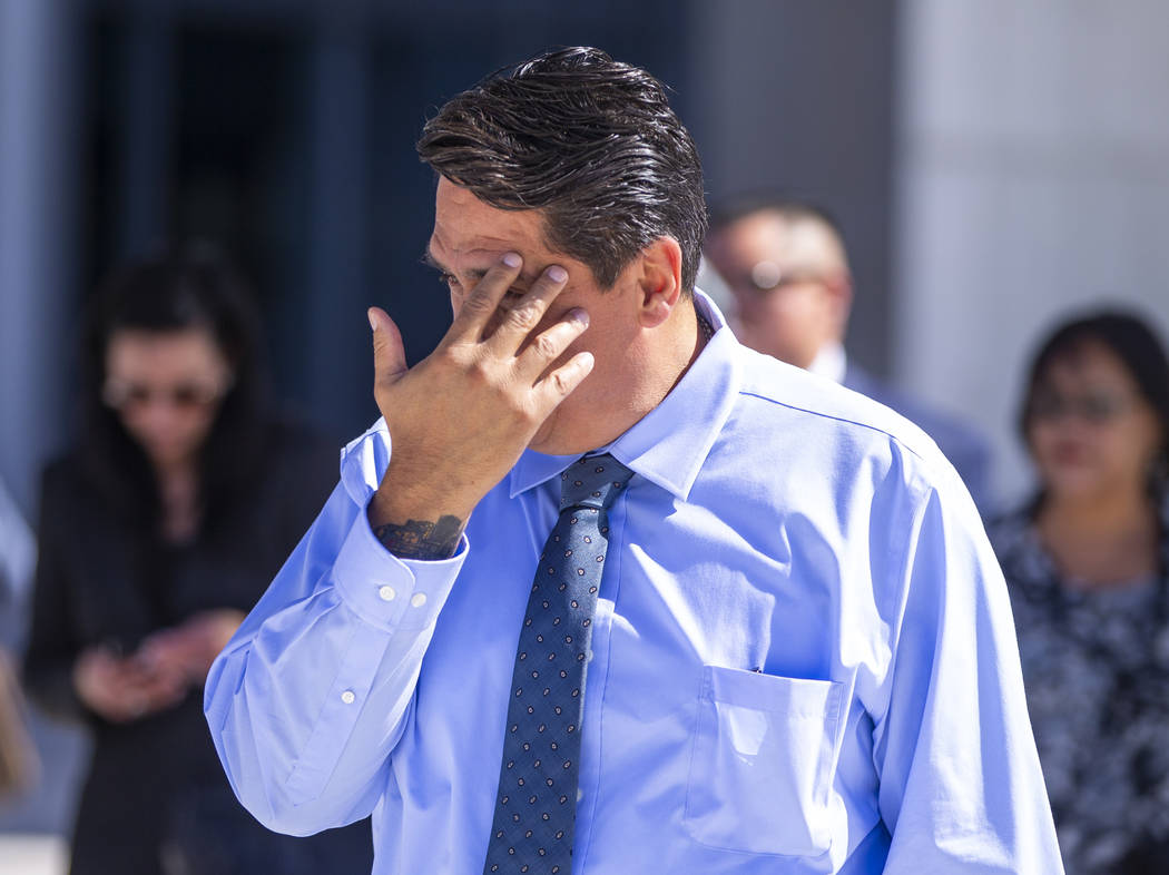 Defendant Bradley Campos hides his face while departing the Lloyd D. George Courthouse followin ...