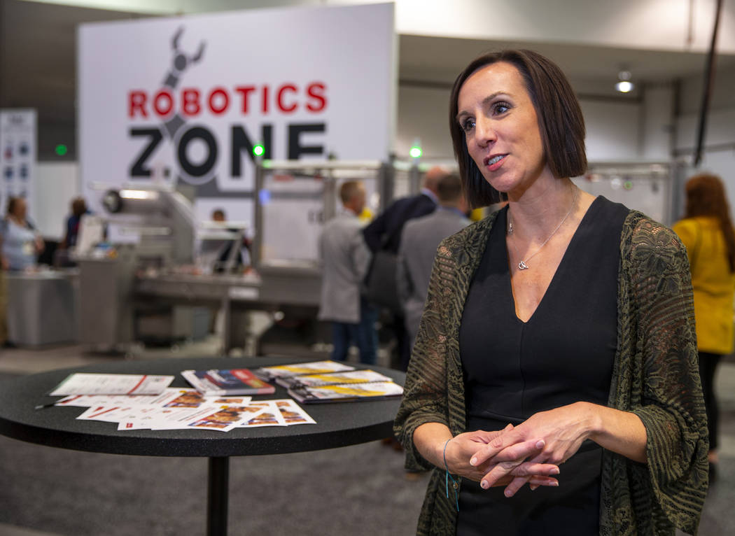 Laura Thompson with PMMI talks about the PACK EXPO and how the robots behind are packing school ...