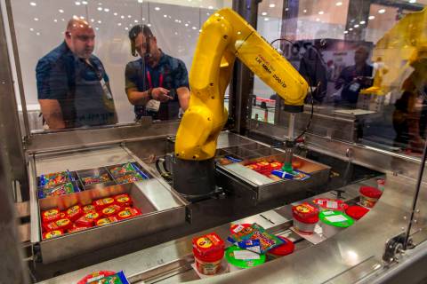 A robot with Bosch Packaging technology Inc. packs school lunches for kids through Blessings in ...
