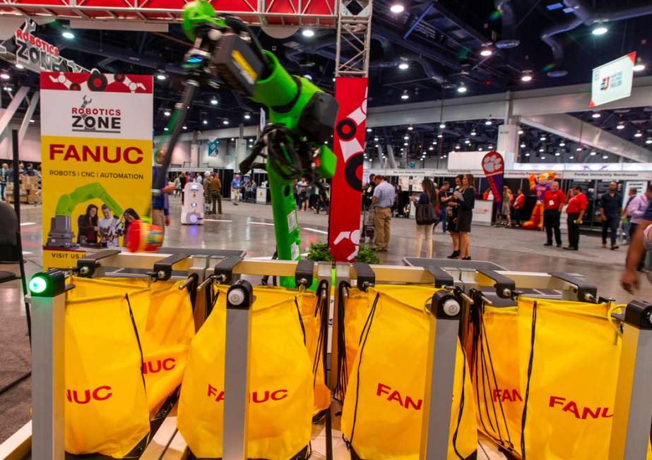 A robot from Fanuc packs school lunches for kids through Blessings in a Backpack at the PACK EX ...