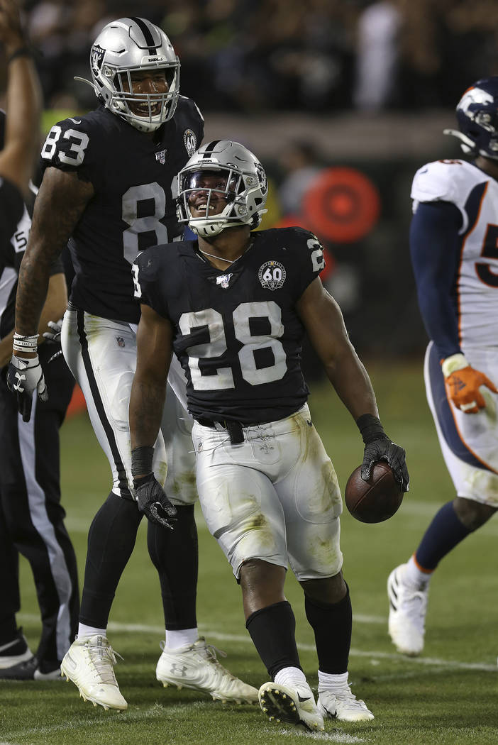 Oakland Raiders running back Josh Jacobs celebrates his first career touchdown with Darren Wall ...