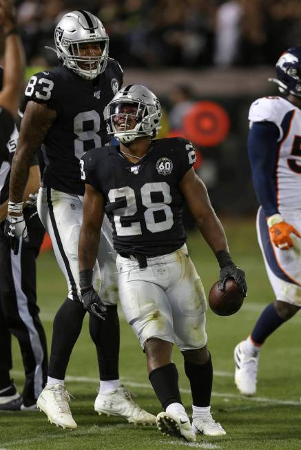 Oakland Raiders running back Josh Jacobs celebrates his first career touchdown with Darren Wall ...