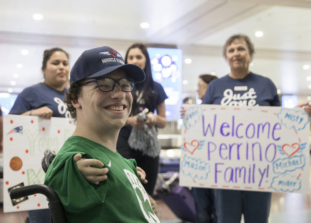 Michael Perrino, 16, from Mashpee, Mass., is greeted by Miracle Flight employees in the ba ...