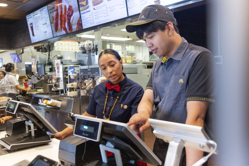 Crew members Glenda Osorio, left, and Jacob Zamora take a customer's order at the McDonald's on ...