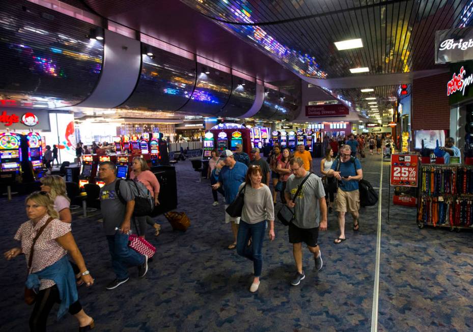 Passengers make their way to baggage claim and transportation at McCarran International Airport ...