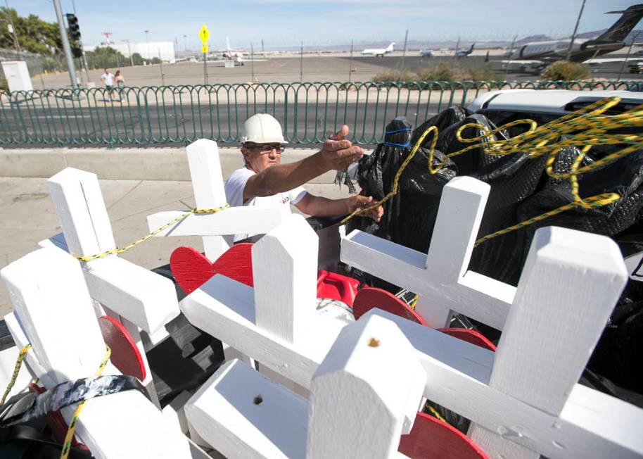 Greg Zanis, of Aurora, Ill., unloads several of the 58 crosses he placed near the Welcome to Fa ...