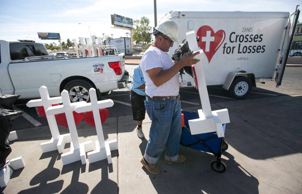 Greg Zanis, of Aurora, Ill., unloads several of the 58 crosses he placed near the Welcome to Fa ...