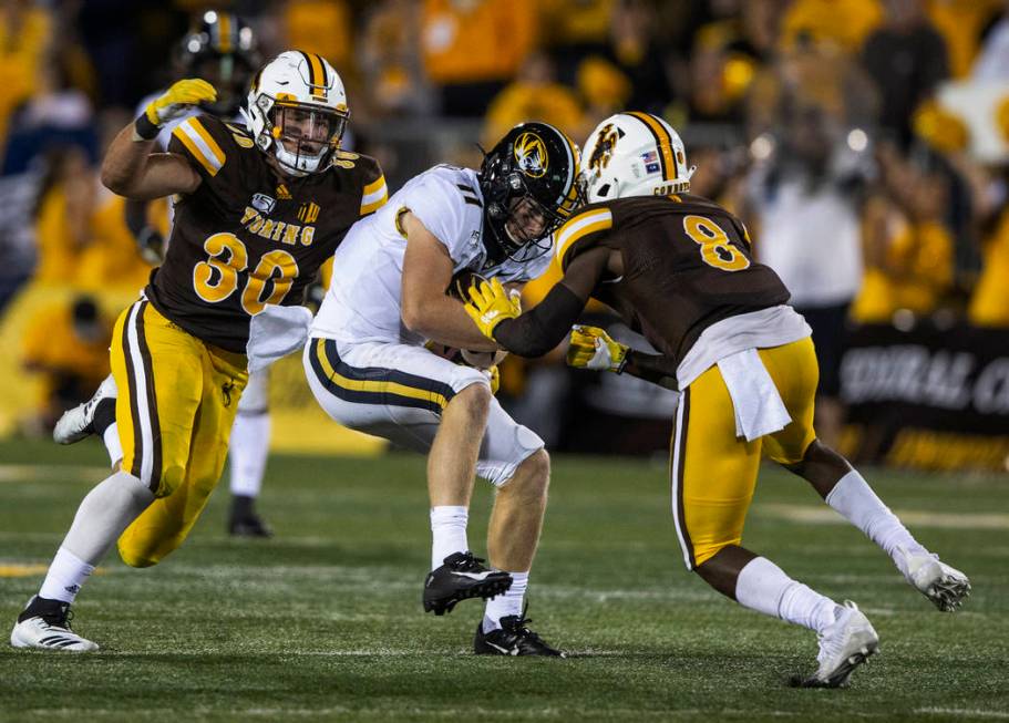 Missouri receiver Barrett Banister (11) is tackled by Wyoming defenders Logan Wilson (30) and R ...