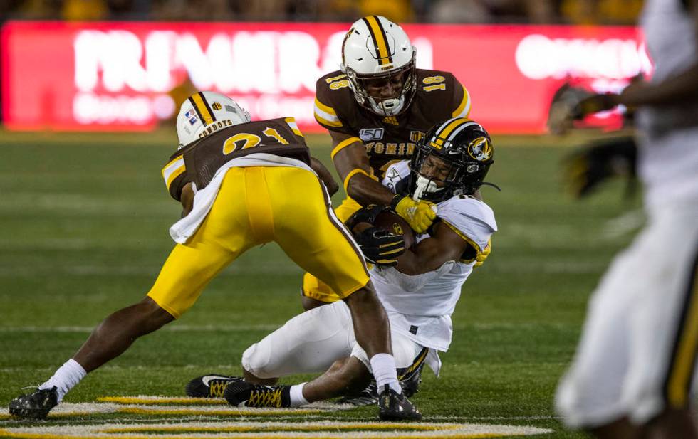 Missouri receiver Jonathon Johnson is tackled by Wyoming defenders C.J. Coldon (21) and Keyon B ...