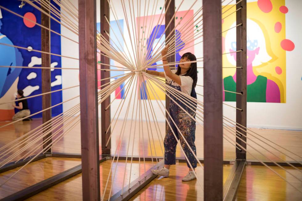 Artist Amanda Phingbodhipakkiya sets up the installation "There Are No Particles Only Fiel ...
