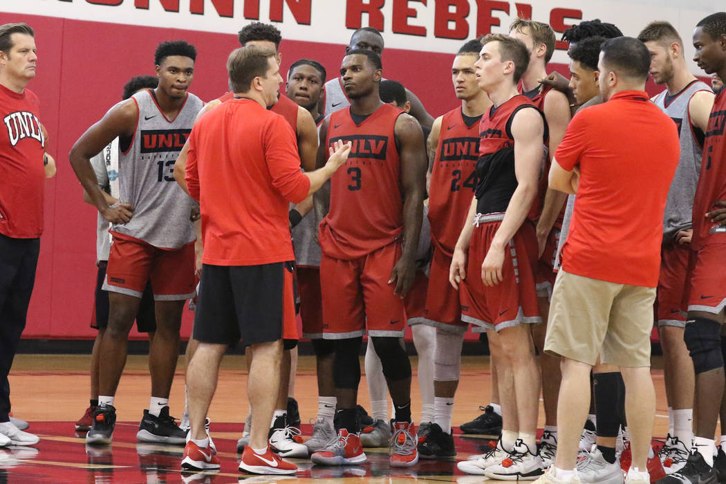 UNLV Rebels head coach T.J. Otzelberger, center, talks to his players after team's first basket ...