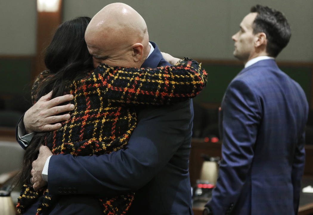 Las Vegas police Lt. James "Tom" Melton, second from left, hugs defense attorney Jean ...