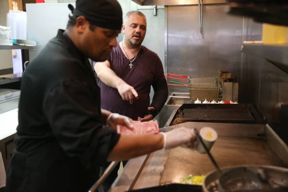 Joe Djavairian, right, owner of Angelina's Pizzeria in Las Vegas, talks to his staff member, ch ...