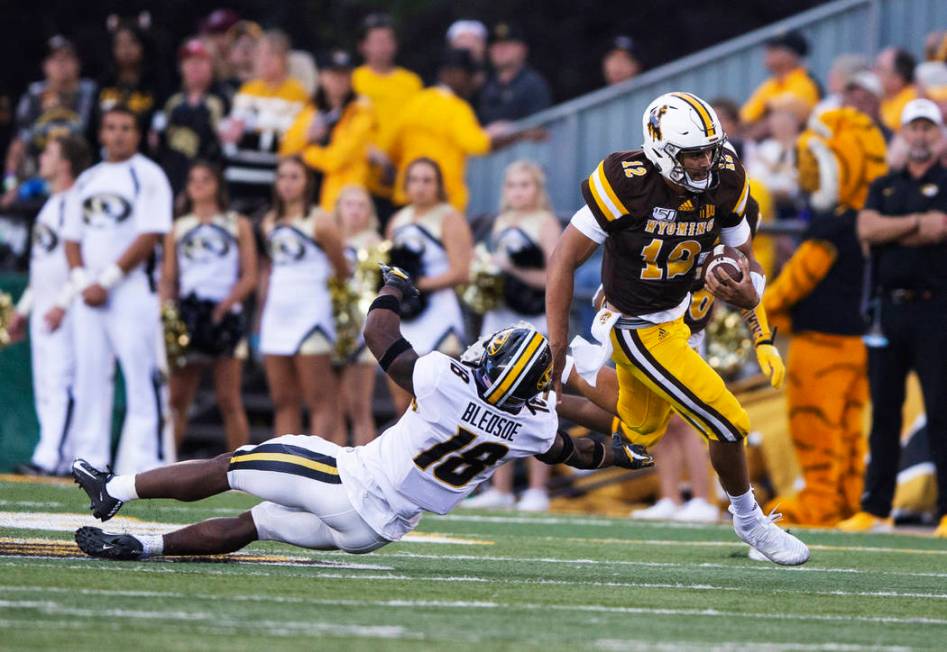 Wyoming quarterback Sean Chambers runs for a touchdown past Missouri defender Joshuah Bledsoe i ...