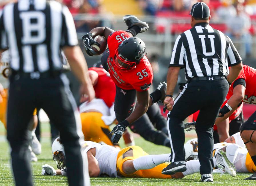 UNLV running back Xzaviar Campbell (35) is tripped up during a football game against Wyoming at ...