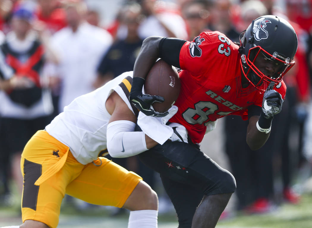 UNLV wide receiver Devonte Boyd (83) is tackled by Wyoming defensive back Marcus Epps (6) durin ...